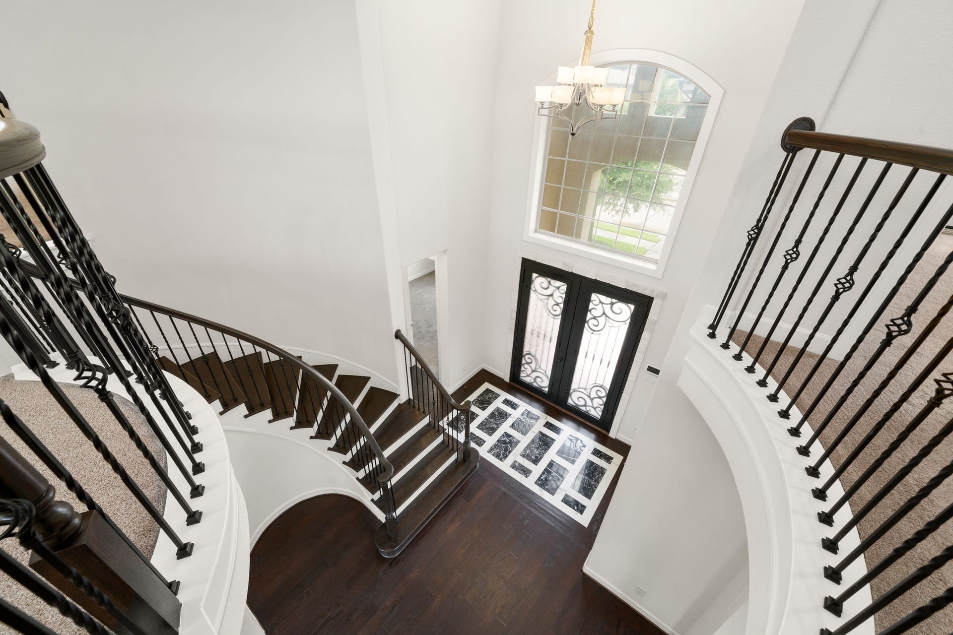 3622 Sage Hollow Drive, Spring, TX 77386 Looking down from the upper level reveals the breathtaking structural artistry of the entry hall, showing off a bespoke wood-to-stone floor inlay with premium interlocking Marble Empress Black tiles framed by Classic Statuarietto white.