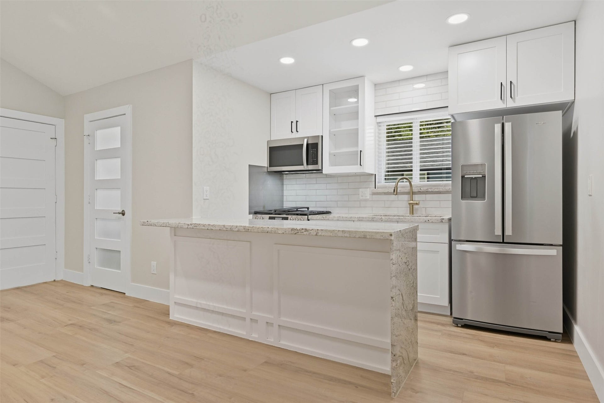 10930 White Thorn Street, #B, Houston, TX 77016 The gorgeous kitchen features a gas stove, built in microwave, tile backsplash, and stainless steel refrigerator.