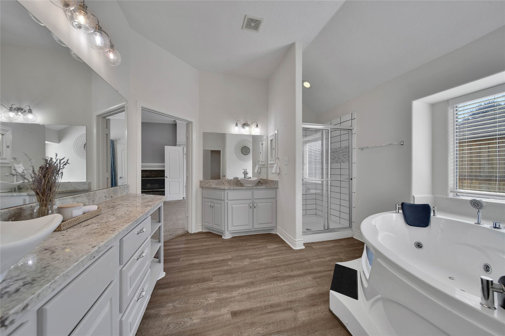 5918 Greenway Manor Lane, Spring, TX 77373 Spacious primary en-suite bathroom, featuring separate vanities, generous counter space, a jetted soaking tub, and a separate glass-enclosed shower.