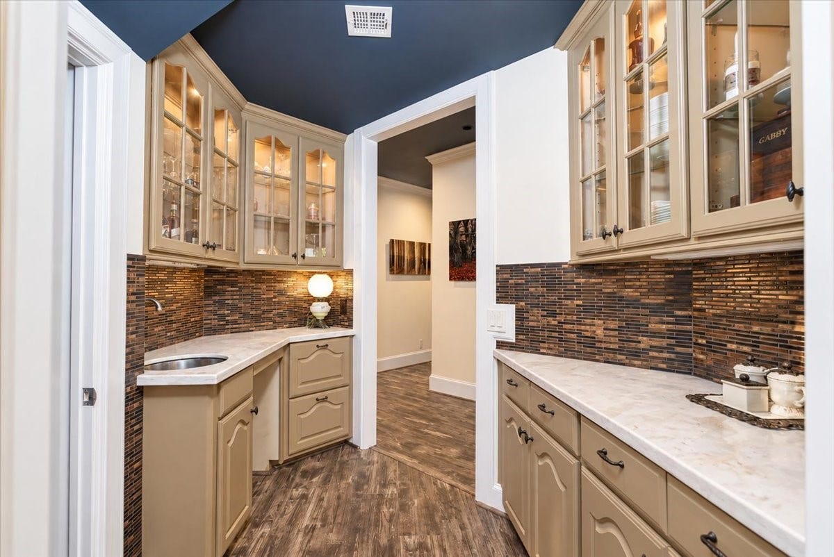 8514 Haven Way, Tomball, TX 77375 Extra storage and prep space just off the kitchen. This butlers pantry features lighted cabinets, glass tile, bar sink and tons of cabinets for all your entertaining needs.