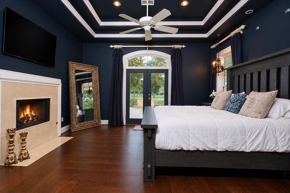 8514 Haven Way, Tomball, TX 77375 Relax in this generously sized primary suite, where a coffered ceiling and a fireplace create a warm, restful mood. Arched French doors bring in natural light and lead to a side patio with open lawn views.