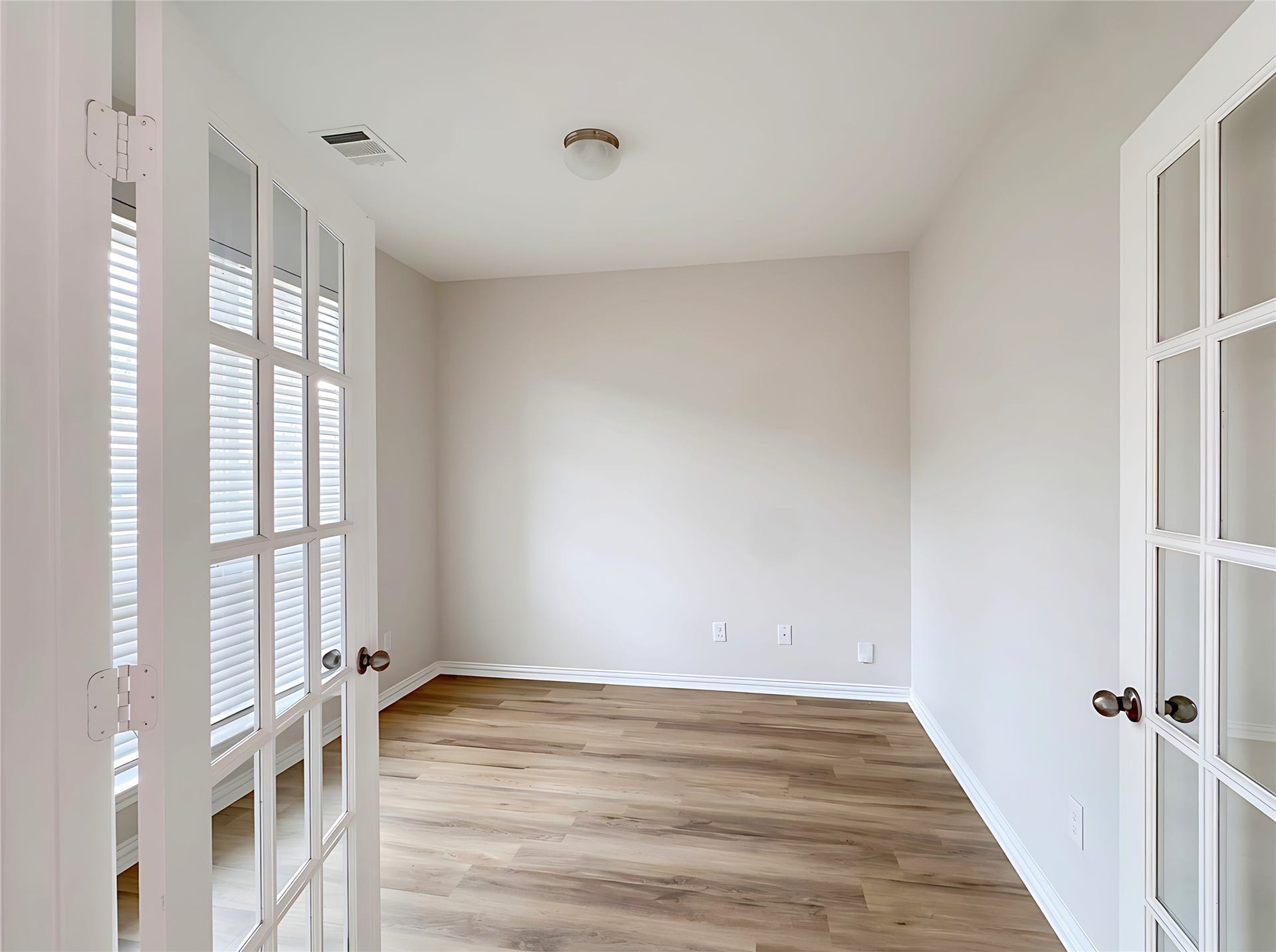 662 W Linnwood Drive, Woodbranch, TX 77357 Bright Office with elegant French doors, featuring wood-style flooring .