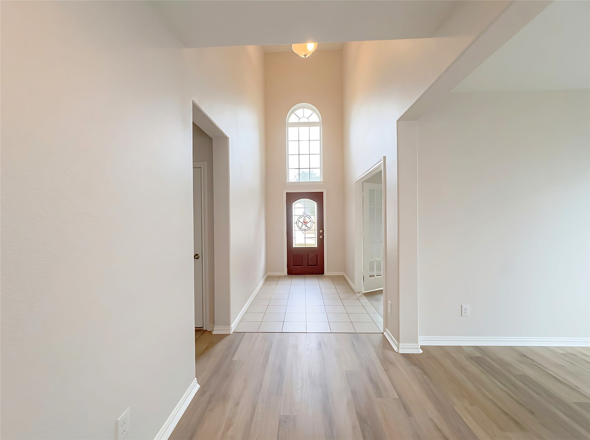 662 W Linnwood Drive, Woodbranch, TX 77357 Bright and welcoming entryway featuring high ceilings, elegant tile flooring, and abundant natural light from the large arched window above the front door.