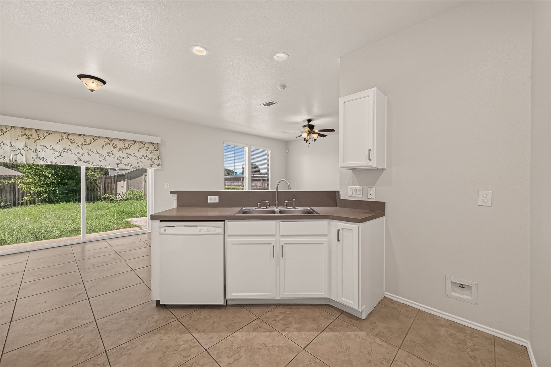 26130 Ripley Hills Drive, Richmond, TX 77406 This photo showcases a backyard with a patio area featuring sliding glass doors, a small bench, and well-maintained grass. A wooden fence offers privacy, and a shed provides extra storage space.