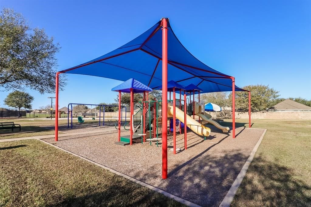 26130 Ripley Hills Drive, Richmond, TX 77406 Discover the perfect family haven with a vibrant kids' play area, complete with shaded slides and swings, nestled in a spacious and sunny outdoor setting.