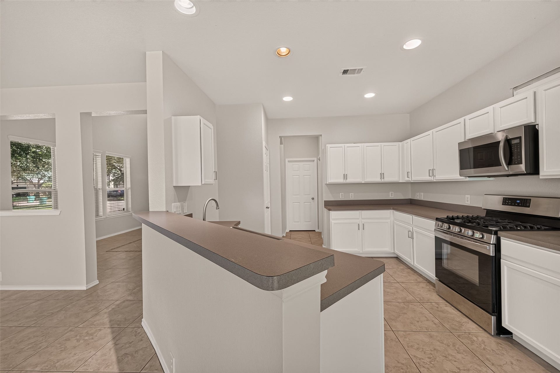 26130 Ripley Hills Drive, Richmond, TX 77406 Bright, open living space with large sliding glass doors leading to a grassy backyard. Features tiled floors, a ceiling fan, and ample natural light. Perfect for indoor-outdoor living.