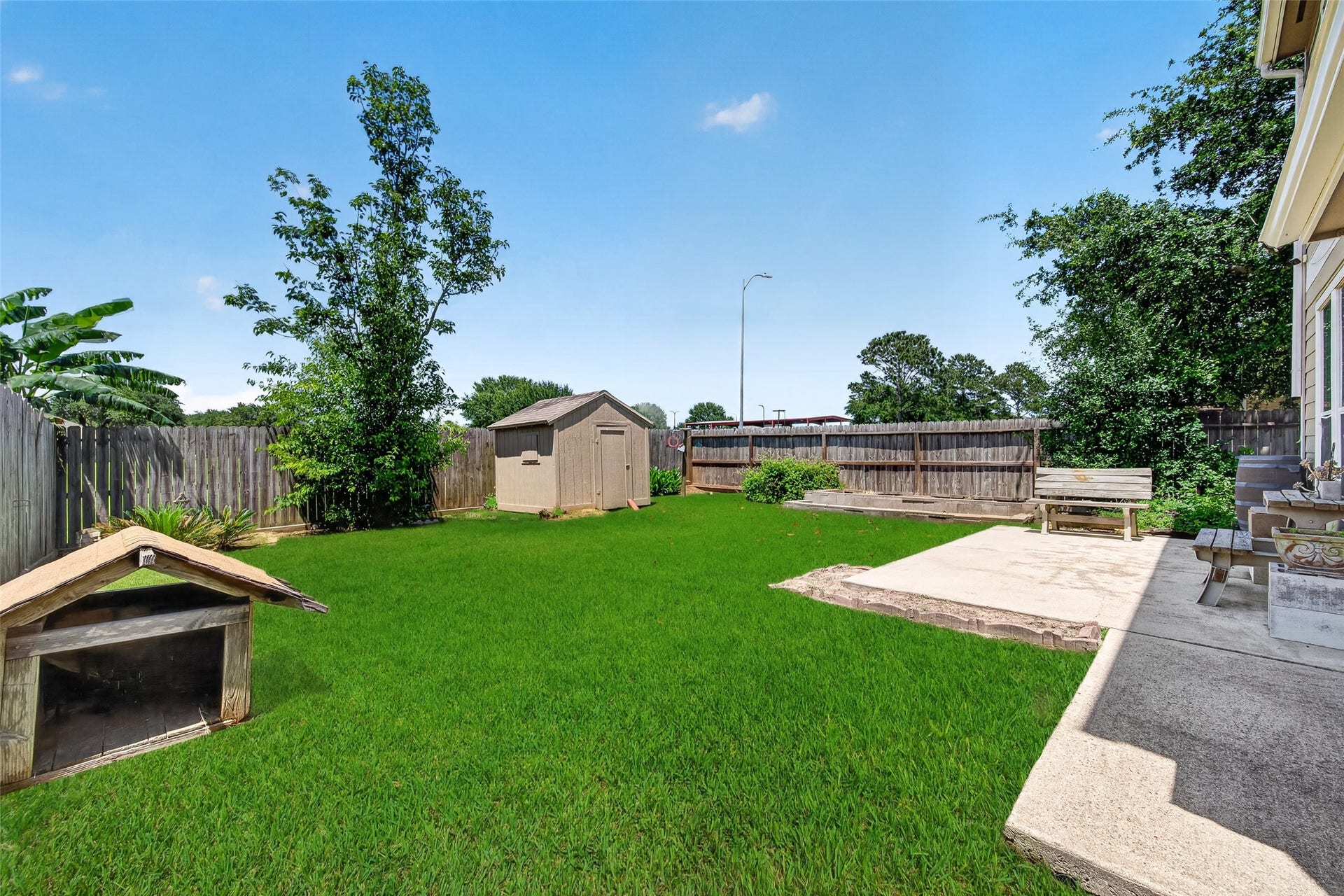 26130 Ripley Hills Drive, Richmond, TX 77406 Spacious backyard with a well-maintained lawn, patio area with seating, and a wooden fence for privacy. Ideal for outdoor activities and relaxation.