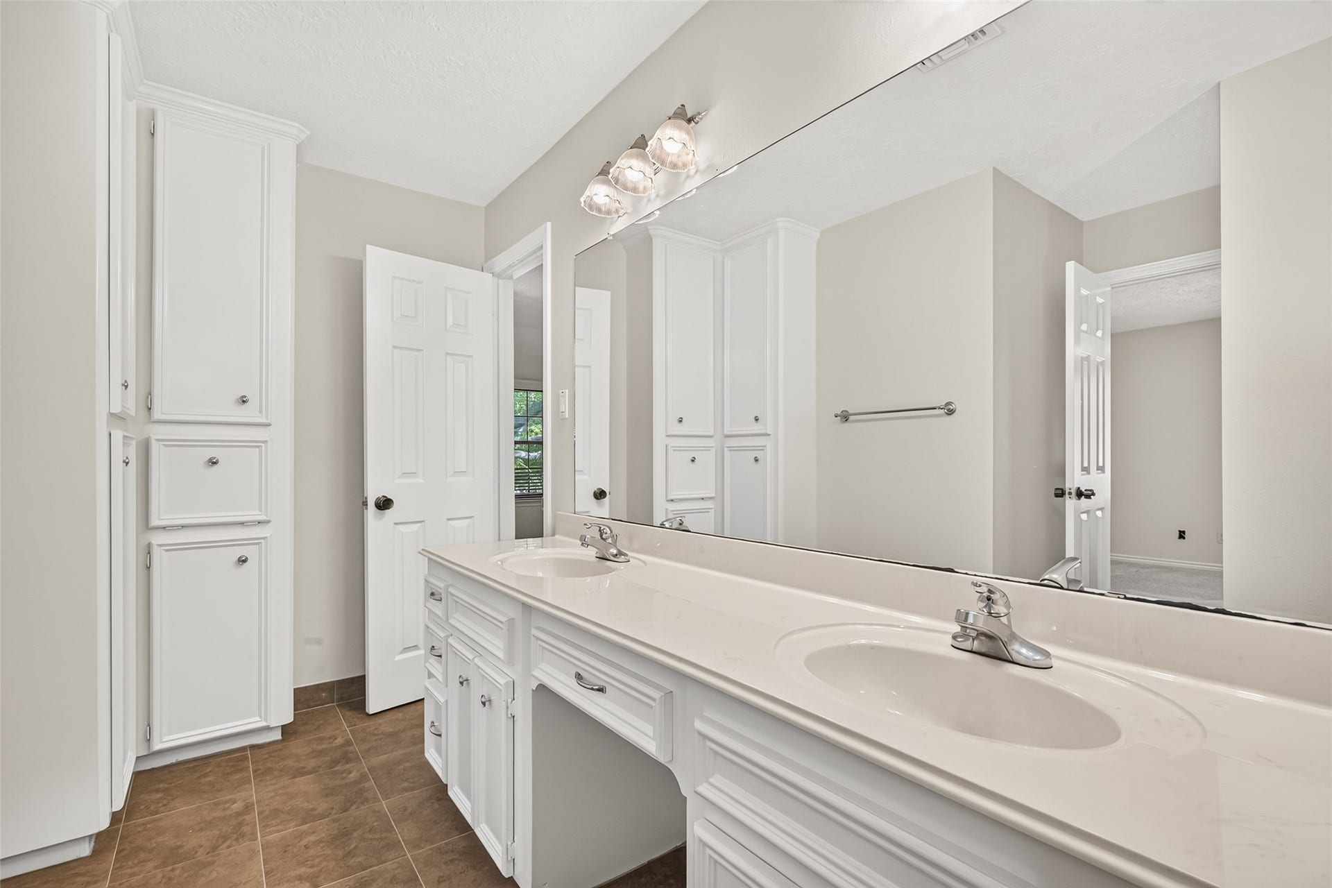 DOUBLE THE SINKS & PLENTY OF STORAGE! This spacious upstairs bathroom offers a long vanity with two sinks, generous countertop space, & built-in drawers for organizing everyday essentials. The convenient knee space between the sinks provides room for a vanity stool, while a floor-to-ceiling wall of linen cabinets offers wonderful storage for towels, toiletries & extra supplies. With the bathing area separated from the vanity, this thoughtful layout makes getting ready in the morning a little easier.