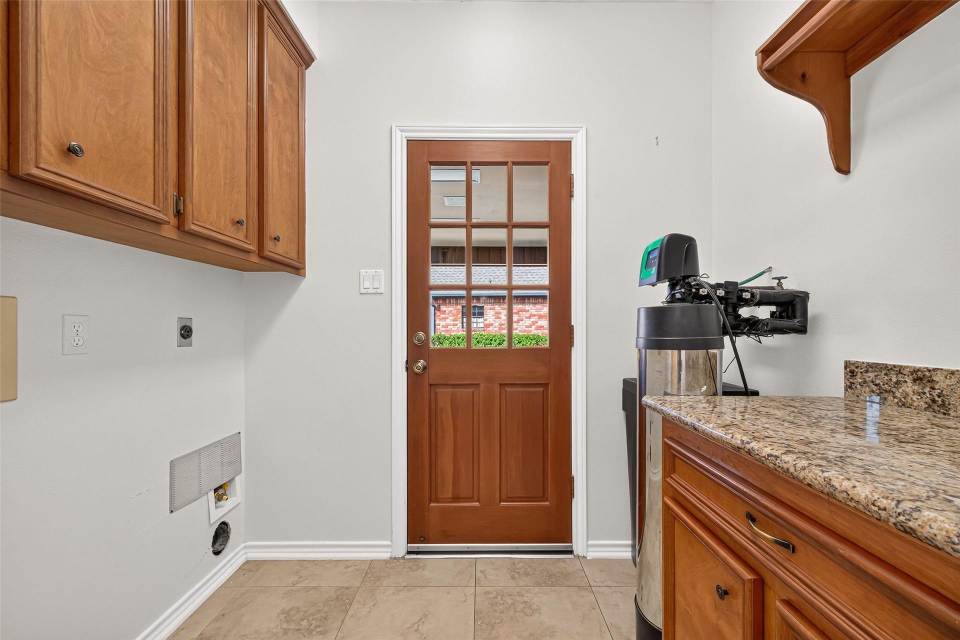 LAUNDRY DAY MADE EASY! Conveniently located between the kitchen & dining room, this utility room offers a folding counter with storage cabinetry to help keep laundry essentials organized. Both gas & electric dryer connections provide flexibility for your appliances. The Rayne water softener helps reduce mineral buildup in plumbing & appliances while allowing you to use less soap, shampoo & even laundry detergent. The exterior door conveniently opens directly to the covered porte cochere.