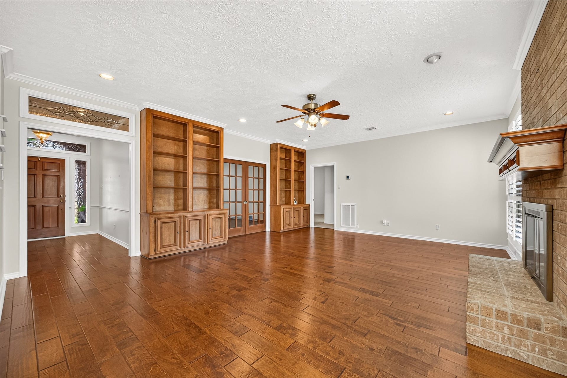 COME IN, GET COMFORTABLE & STAY AWHILE! Rich hardwood floors, built-in bookshelves, recessed lighting & a ceiling fan make this spacious family room a wonderful place to relax. Notice the decorative leaded-glass transom above the doorwaya charming detail that echoes the foyer. Imagine curling up with a favorite book, settling in for movie night or enjoying an evening of conversation with friends. French pocket doors lead to the adjoining first-floor study, offering a convenient space for working from home.