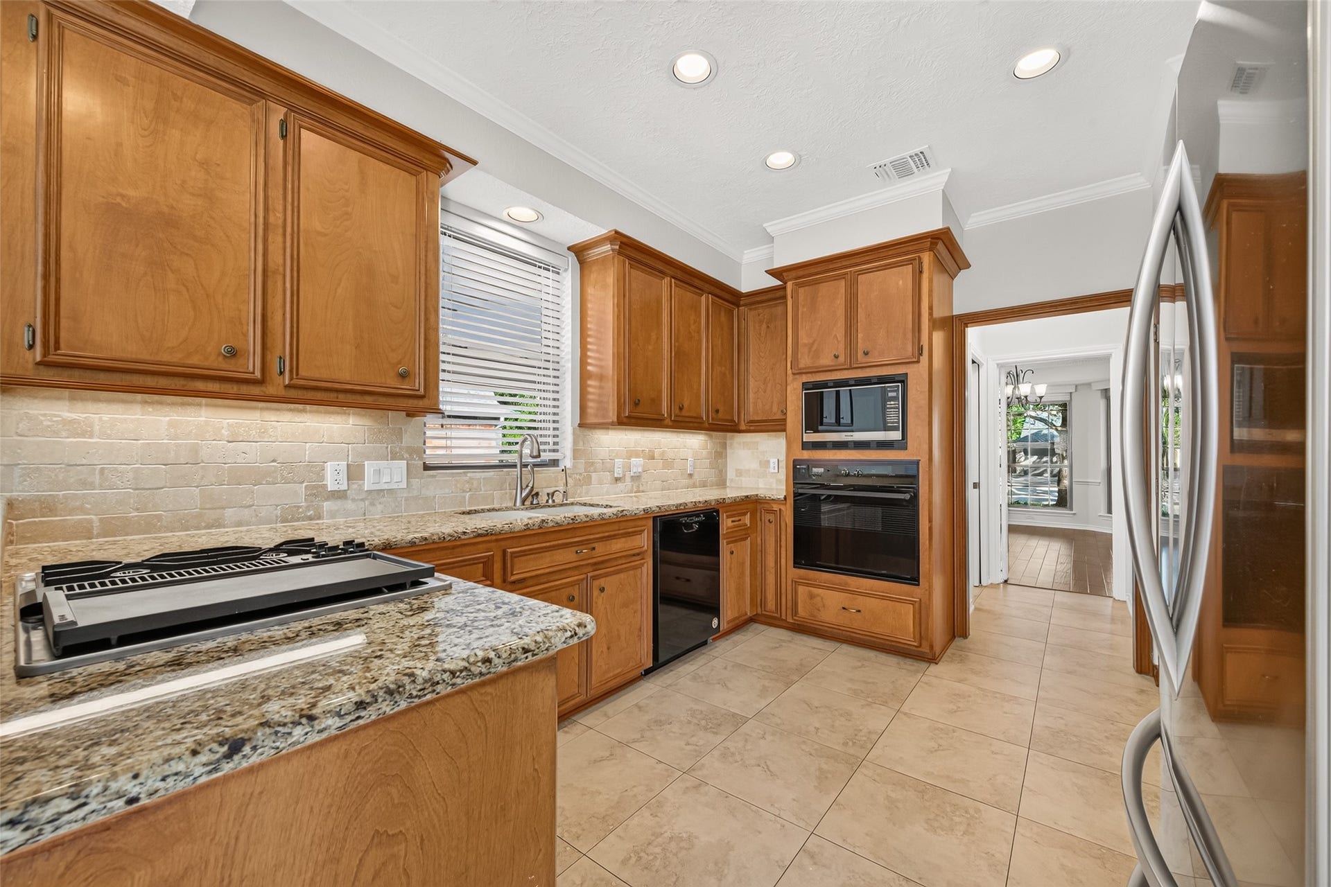 THE HEART OF THE HOME! Whether preparing a favorite weekly go-to recipe or putting together a celebratory feast, this inviting kitchen offers plenty of workspace with granite countertops, hardwood cabinetry, subway tile backsplash & tile flooring. Recessed & under-cabinet lighting brighten the room, while the convenient layout keeps everything within reach. With the formal dining room at one end & breakfast room at the other, it's easy to move from everyday meals to special occasions.