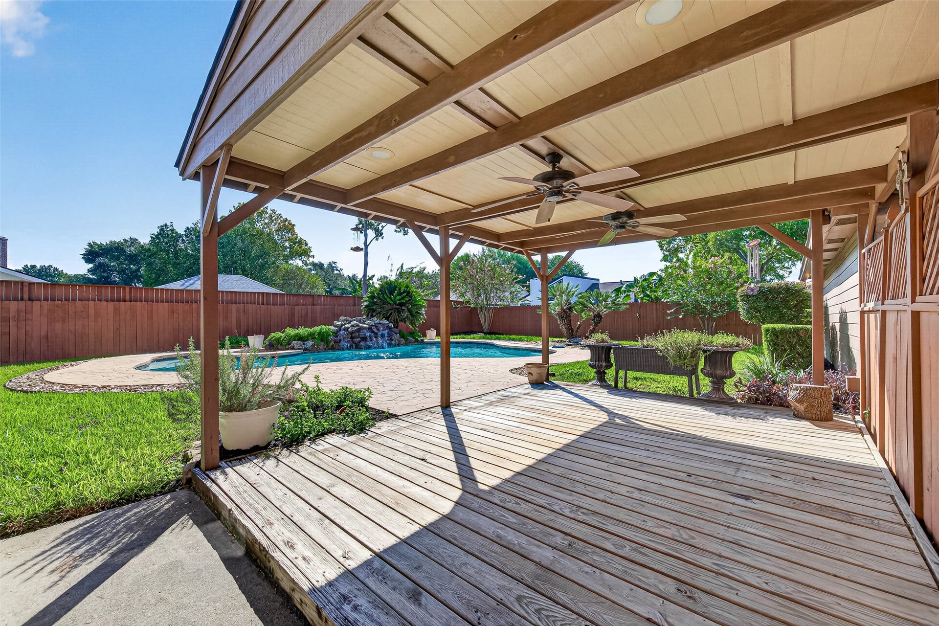PULL UP A CHAIR & STAY AWHILE! This spacious covered wood deck offers a wonderful place to enjoy the outdoors while overlooking the swimming pool & beautifully landscaped backyard. Imagine sipping your morning coffee, enjoying lunch in the shade or settling in with a good book on a lazy afternoon. Two ceiling fans help keep the air moving during warm Texas weather, while the generous deck provides plenty of room for outdoor dining furniture & comfortable seating. Great for outdoor barbecues!