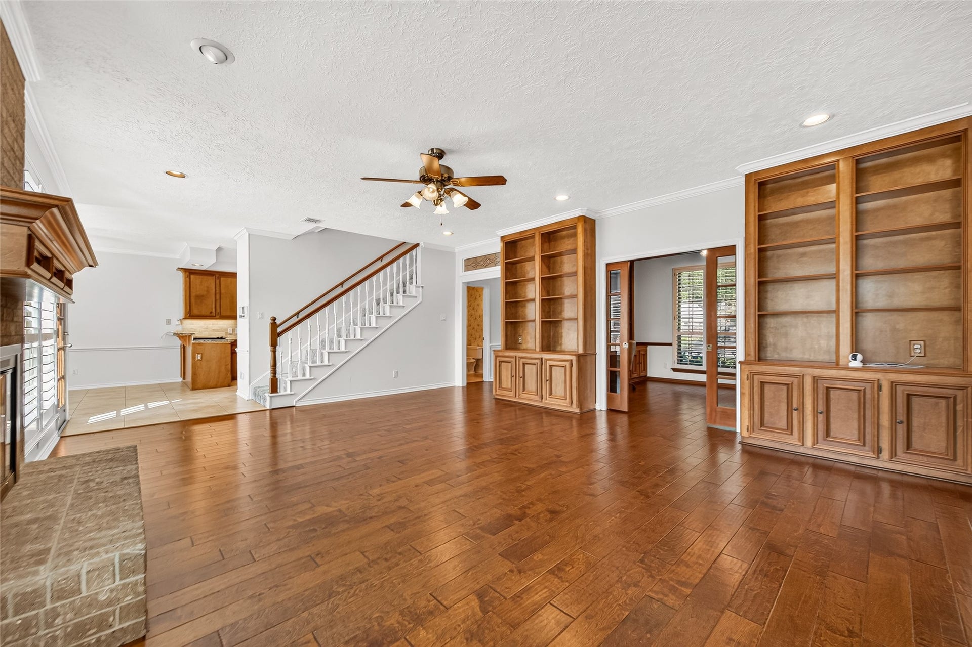 A FLOOR PLAN THAT WORKS FOR YOU! This view highlights the convenient connection between the family room & adjoining first-floor study. French pocket doors allow you to open the space for easy access or close it when privacy is needed. Notice the intercom control panel on the wall near the staircase? Yes, this home has a WORKING intercom system! Enjoy listening to the radio throughout the house or use the intercom to call everyone downstairs for dinner. A fun bit of practical "old-school" nostalgia.