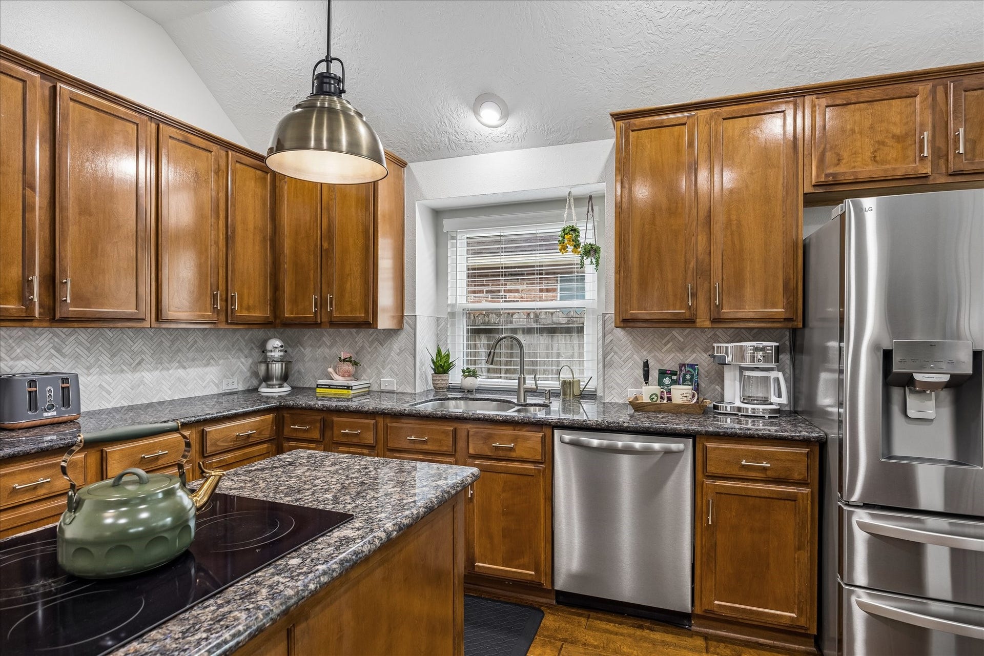 4114 Stonehurst Drive, Pearland, TX 77584 Designed with the home chef in mind! The spacious center island features a built-in cooktop, offering generous workspace and an efficient layout that makes everything from everyday meal preparation to hosting gatherings a breeze.