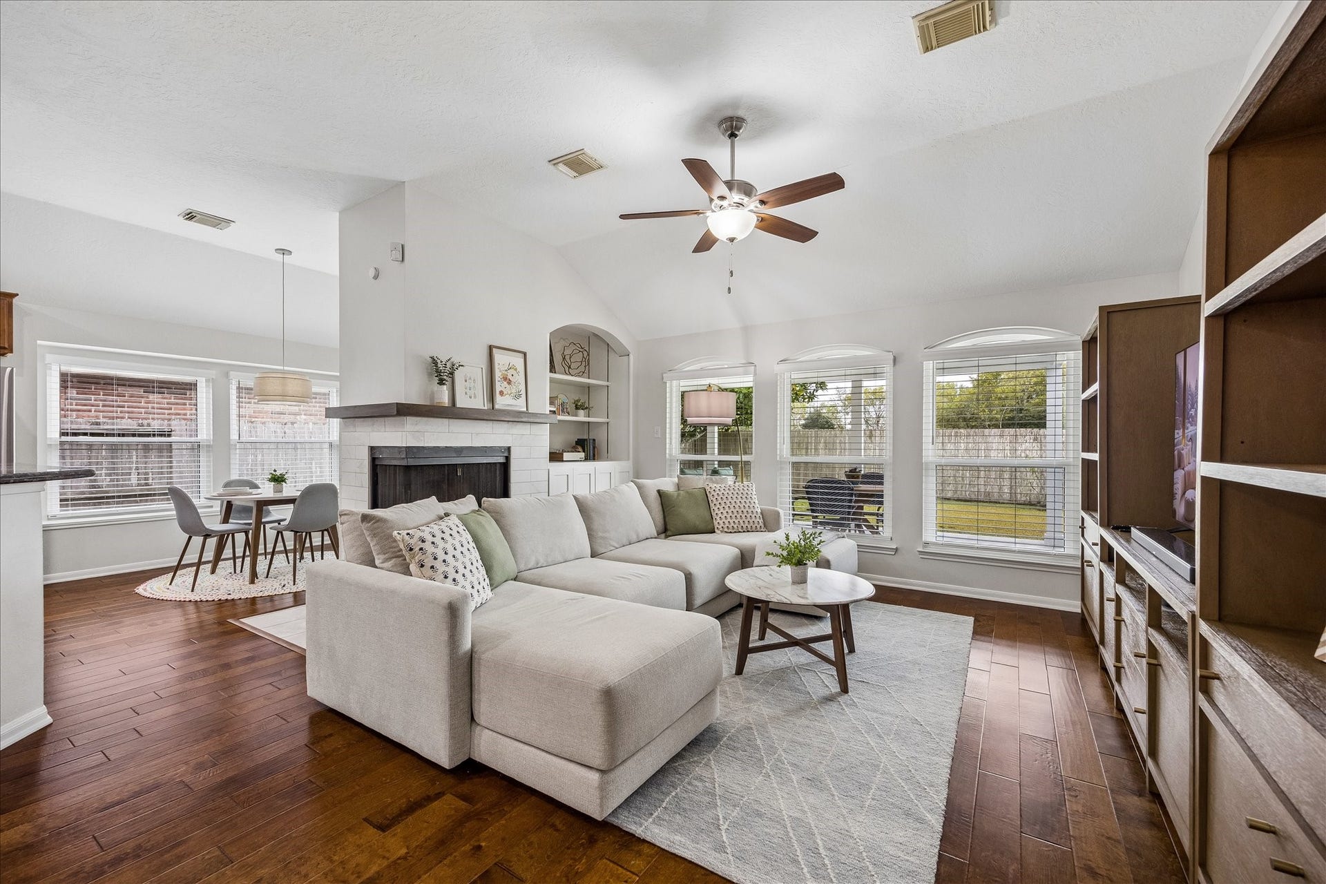 4114 Stonehurst Drive, Pearland, TX 77584 The heart of the home! This beautifully appointed family room features soaring ceilings, gorgeous built-ins, a striking remodeled fireplace, and walls of windows that fill the space with natural light. The perfect blend of elegance and everyday comfort!