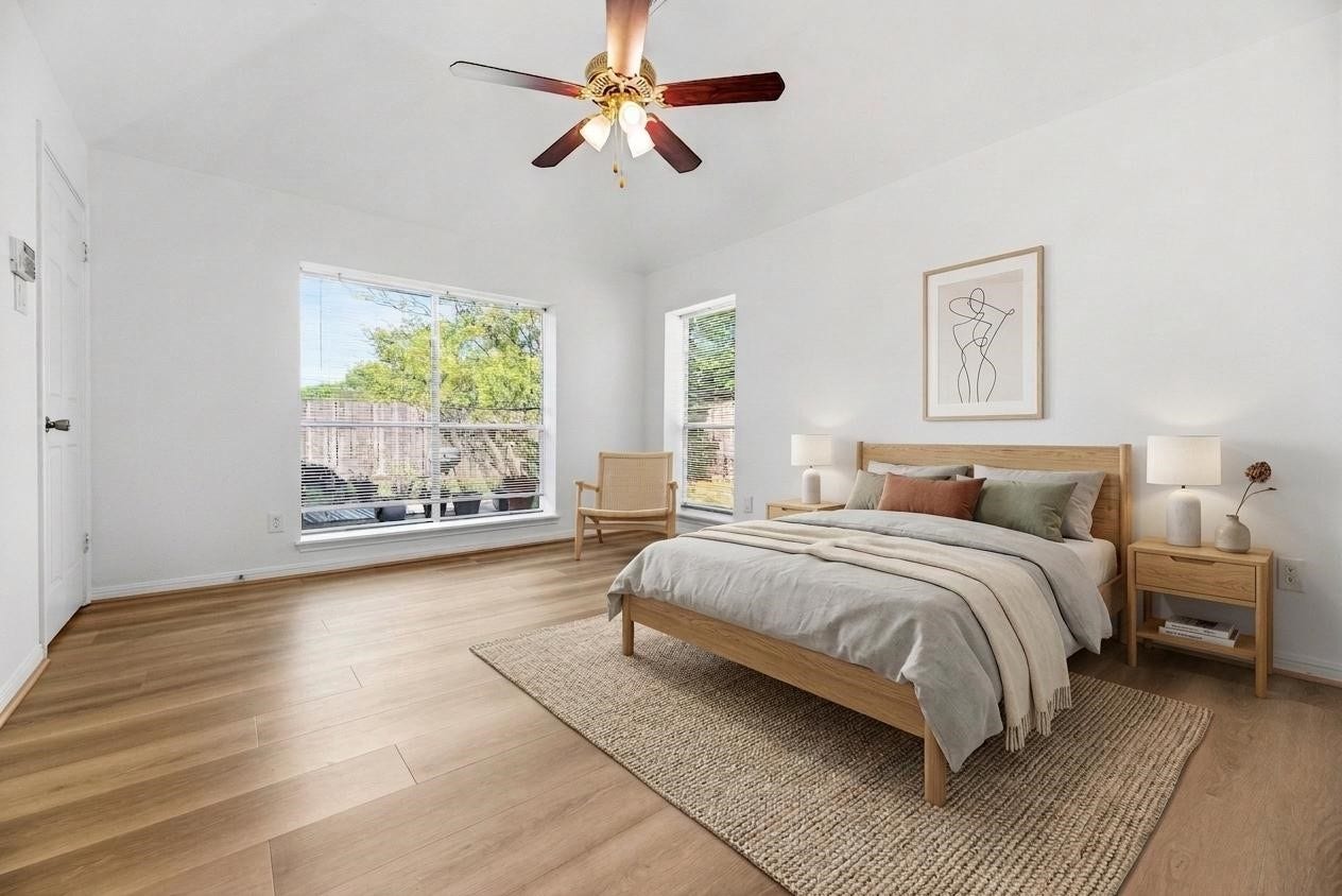 *virtually staged* Spacious Primary Bedroom complete with multiple large windows, sleek LVP floors, ceiling fan, and bright paint.