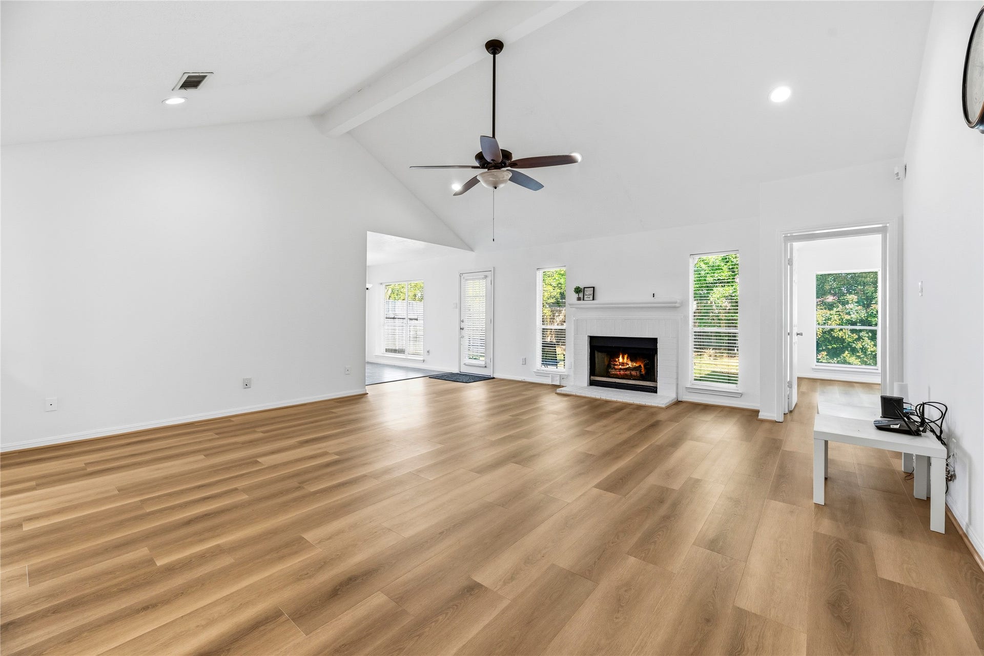 Spacious family room with fresh bright paint, recessed lights, wide plank LVP floors, and convenient access to the kitchen.