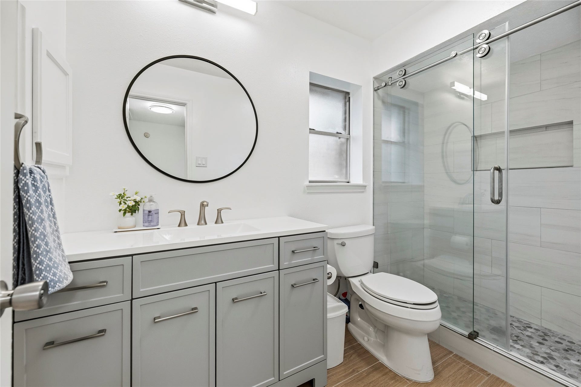 Fully renovated secondary bathroom with a sleek vanity, new fixtures, and a large walk-in shower.