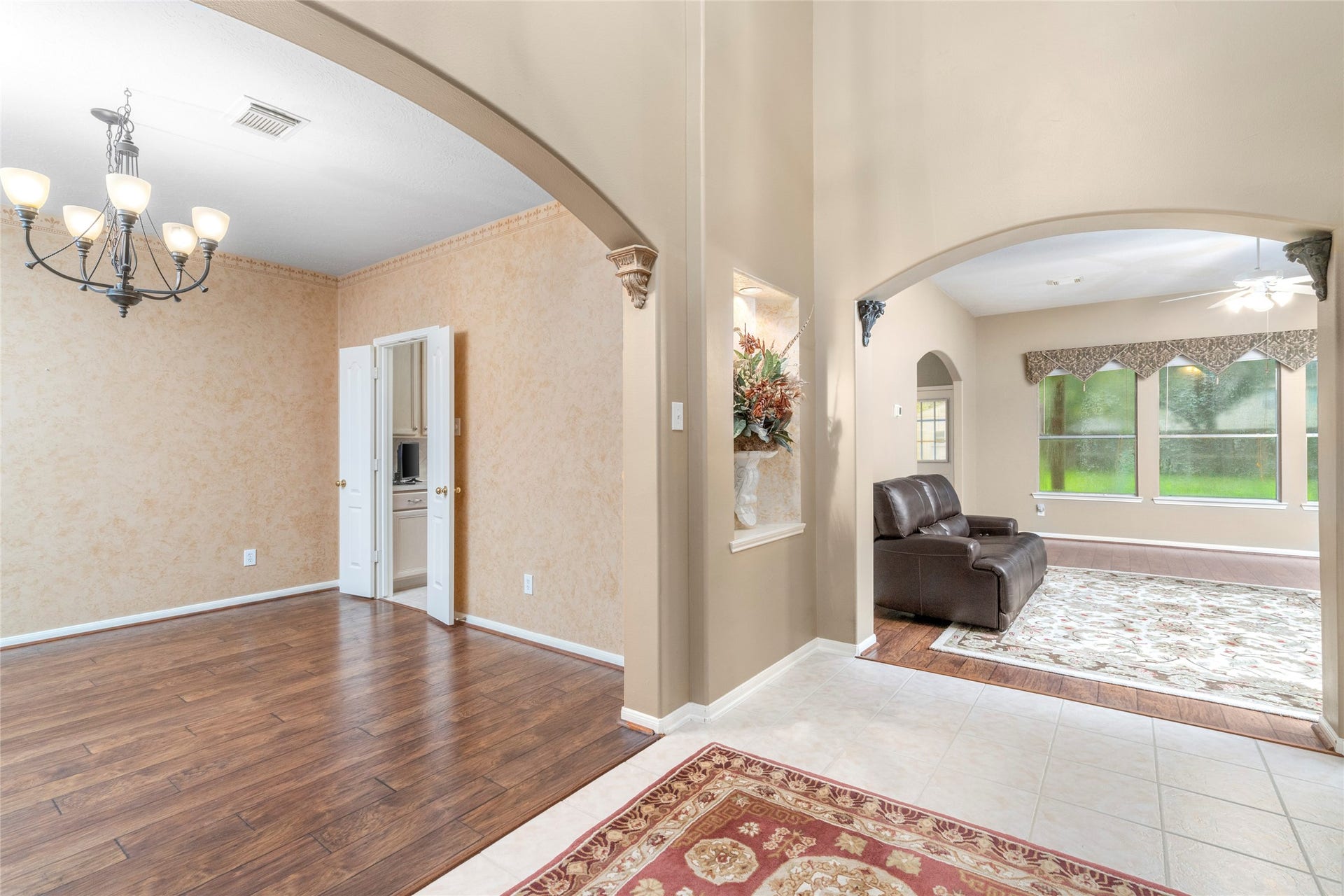 Light-filled interior showcasing the home's open feel, architectural archways, and wood-look flooring. The generous natural light and connection between spaces make this a welcoming area for both everyday living and entertaining.