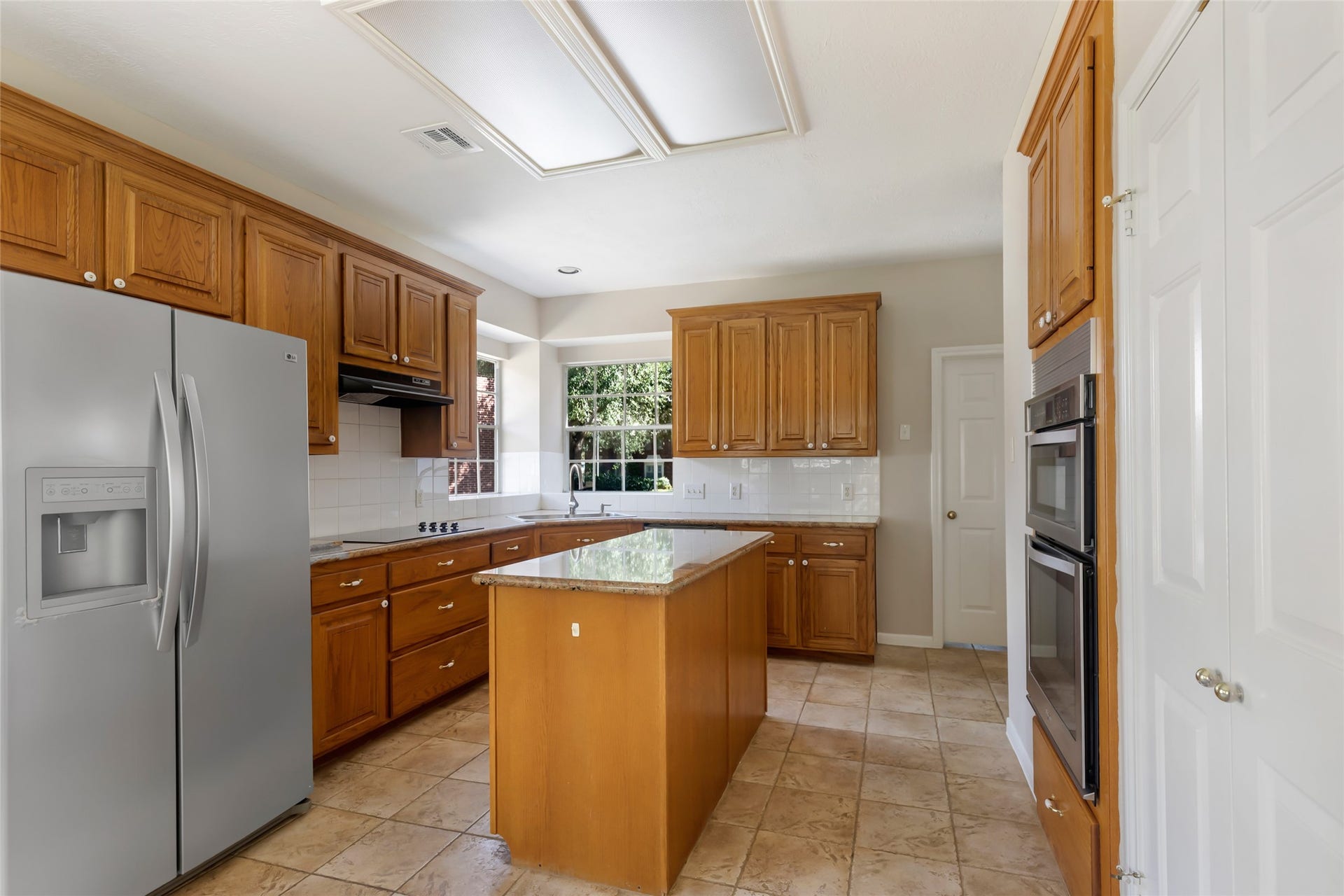 2007 Southern Place, Richmond, TX 77406 Custom warm stained wood cabinets with island. Refrigerator is included.