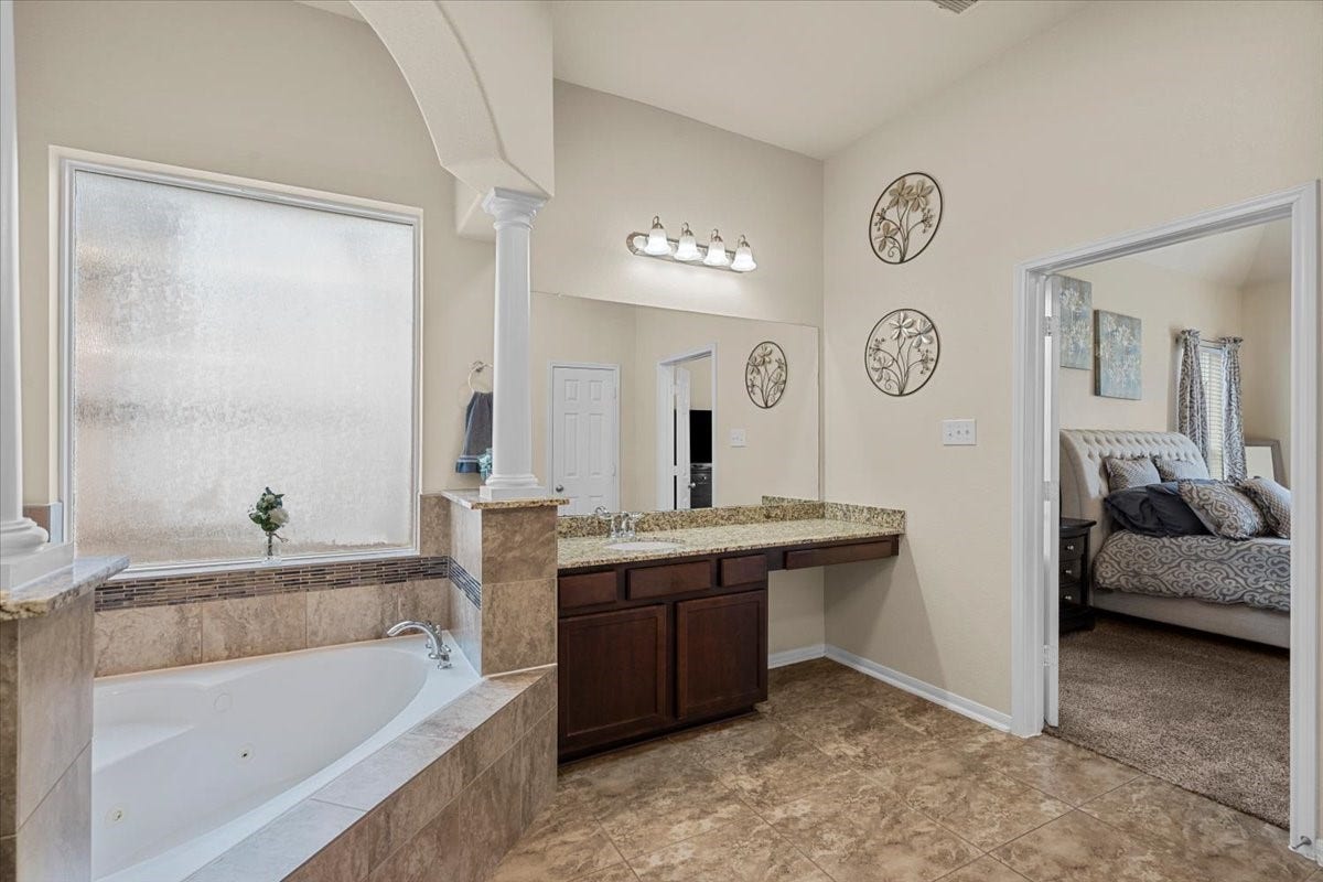 4329 S Meridian Greens Drive, Dickinson, TX 77539 Primary bath with soaking tub, vanity, and direct access to the bedroom.