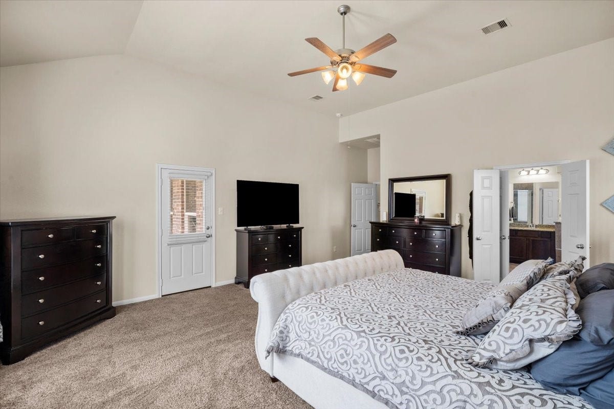 4329 S Meridian Greens Drive, Dickinson, TX 77539 Another angle of the primary bedroom with ceiling fan and soft carpet.