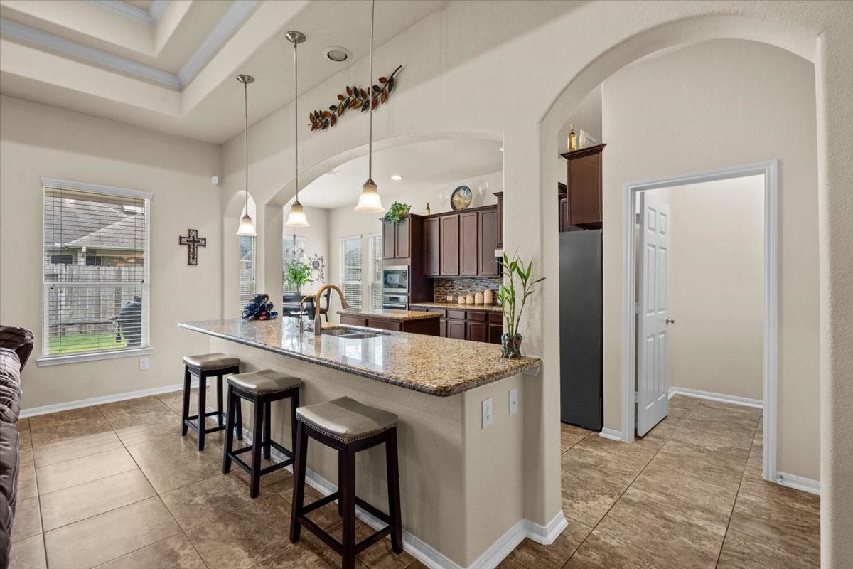 4329 S Meridian Greens Drive, Dickinson, TX 77539 Kitchen with breakfast bar seating and graceful arched details.
