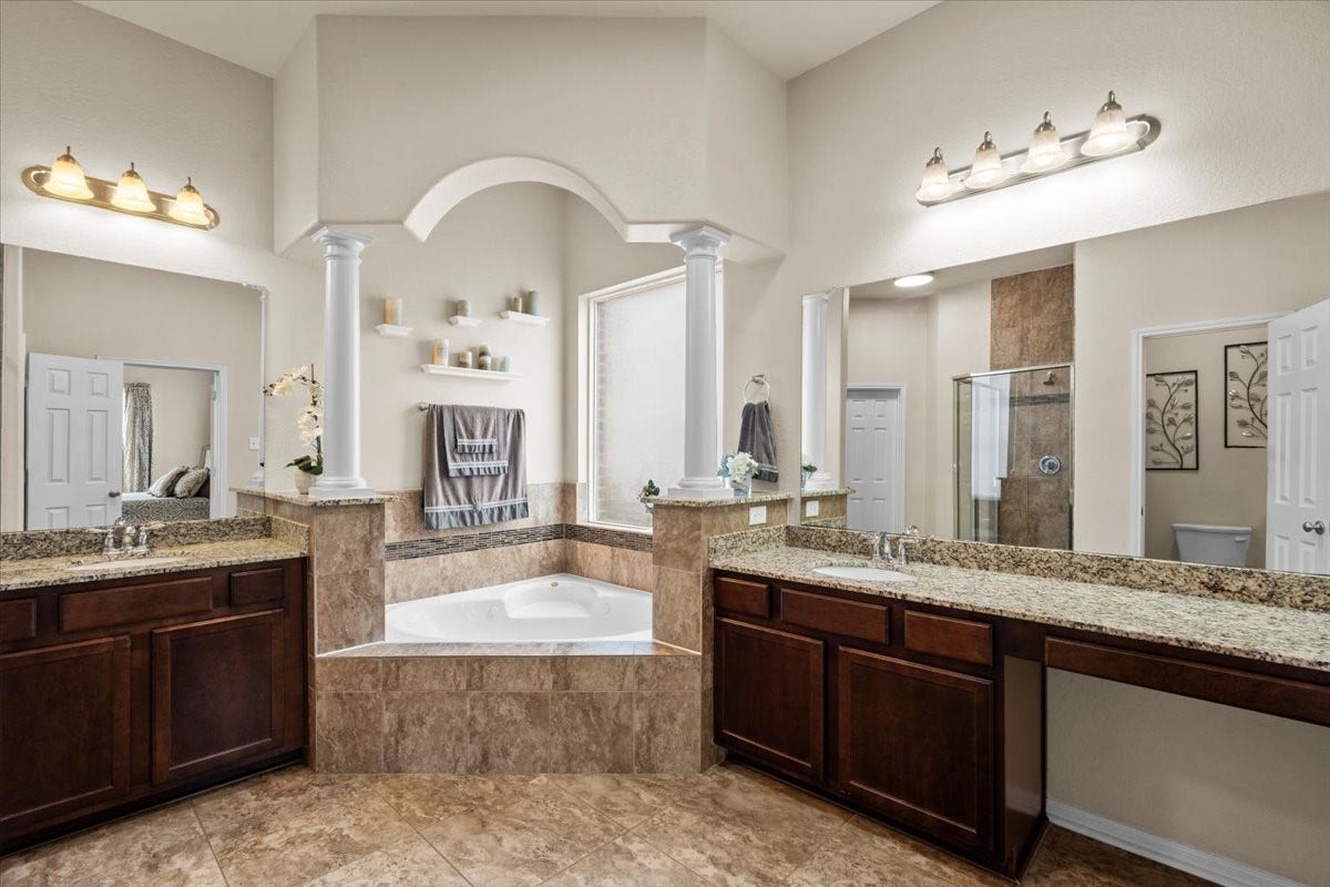 4329 S Meridian Greens Drive, Dickinson, TX 77539 Primary bath with dual vanities and a corner soaking tub.