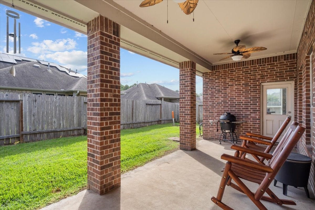 4329 S Meridian Greens Drive, Dickinson, TX 77539 Covered patio with ceiling fans overlooking the fenced backyard.