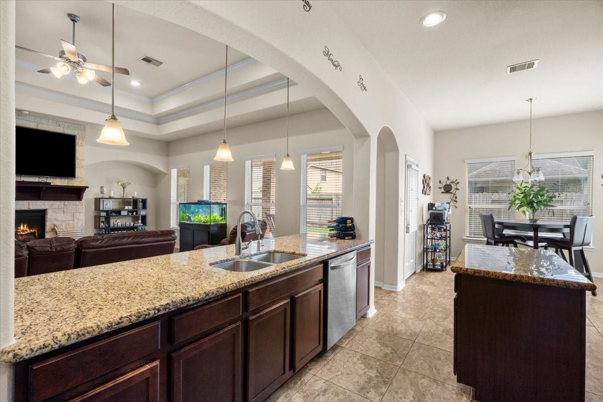 4329 S Meridian Greens Drive, Dickinson, TX 77539 Granite counters and a long breakfast bar connect the kitchen to the living space.