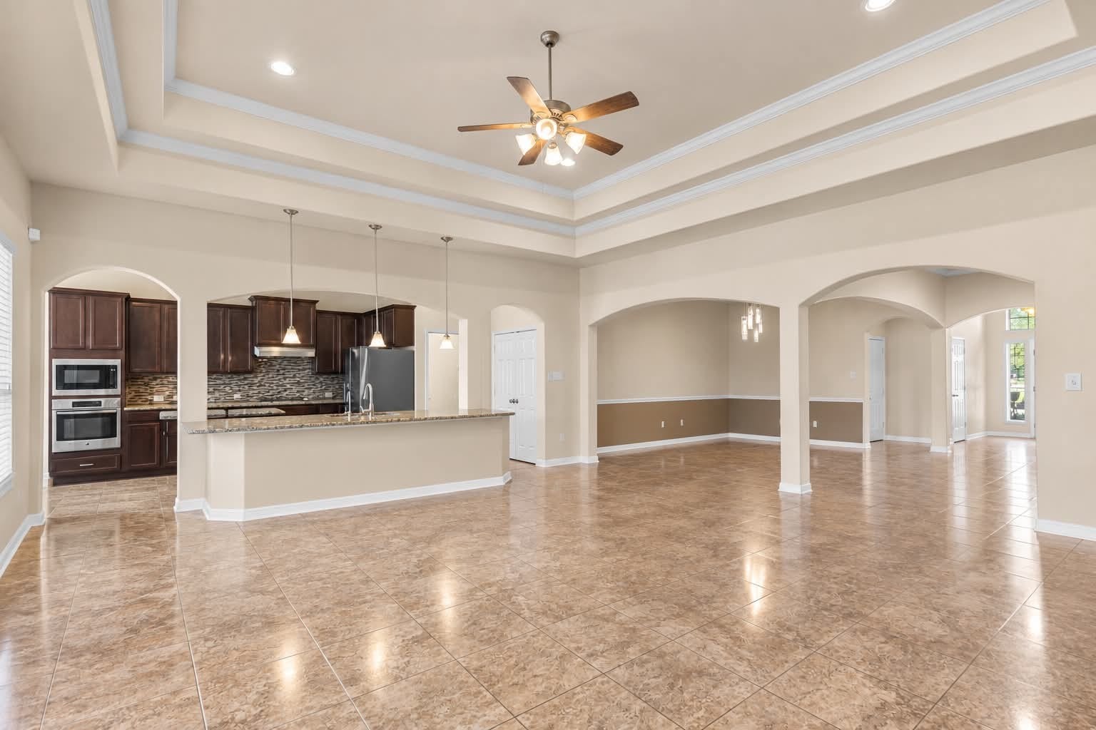 4329 S Meridian Greens Drive, Dickinson, TX 77539 Open living space with arched openings connecting to the kitchen and dining areas.