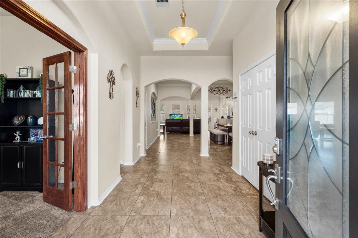 4329 S Meridian Greens Drive, Dickinson, TX 77539 Entry hall with arched openings and French doors opening to a flexible room.