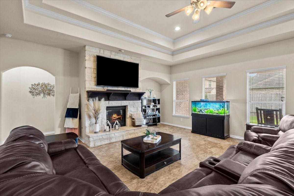 4329 S Meridian Greens Drive, Dickinson, TX 77539 Spacious family room with tray ceiling, cozy fireplace, and room for everyone to gather.