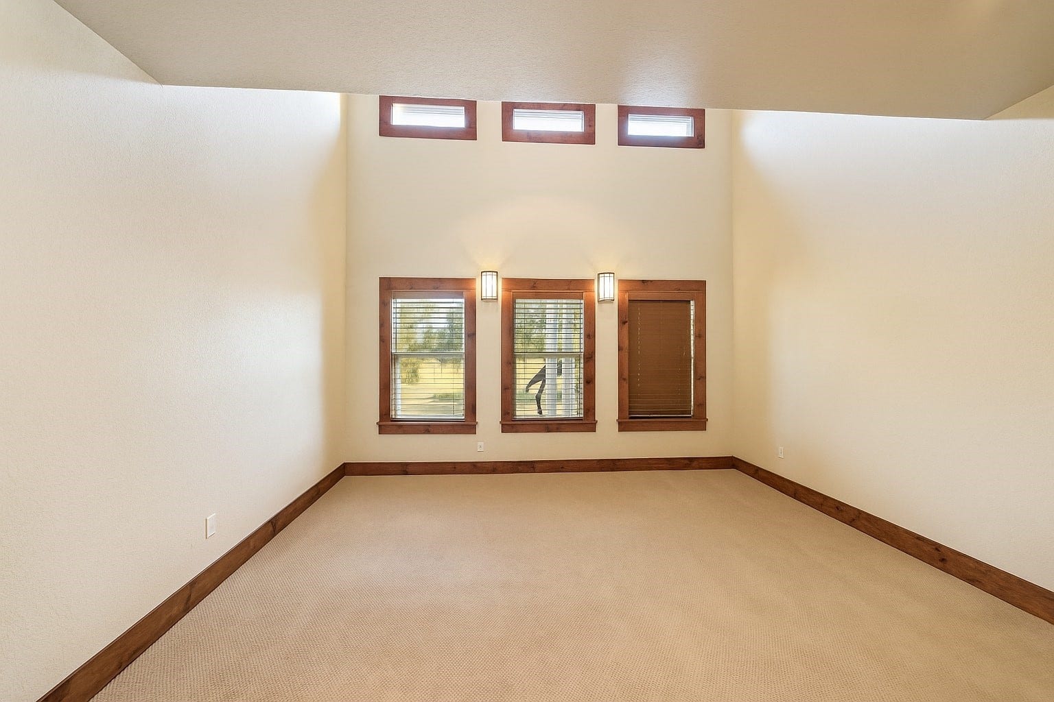 A second view of the serene primary suite reveals abundant space for a sitting area or entertainment setup. Virtually decluttered to help visualize potential use.