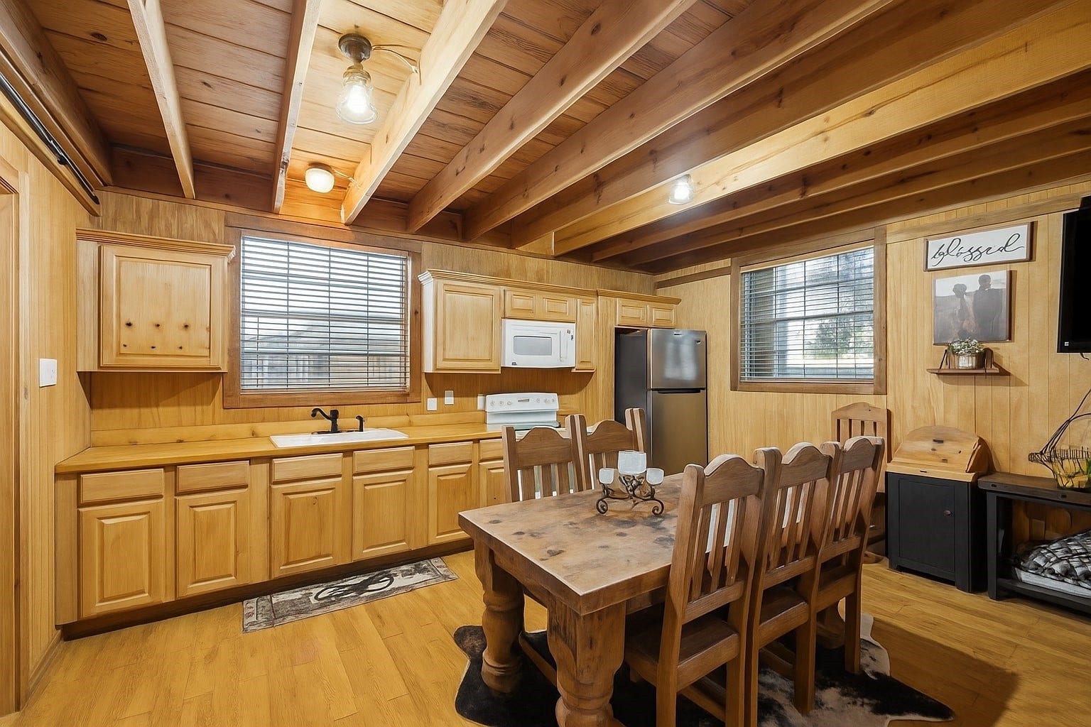 The guest house kitchen includes abundant cabinetry, a full appliance suite, and a spacious dining area beneath exposed beams. Its a fully functional space designed for cooking, entertaining, or extended stays.
