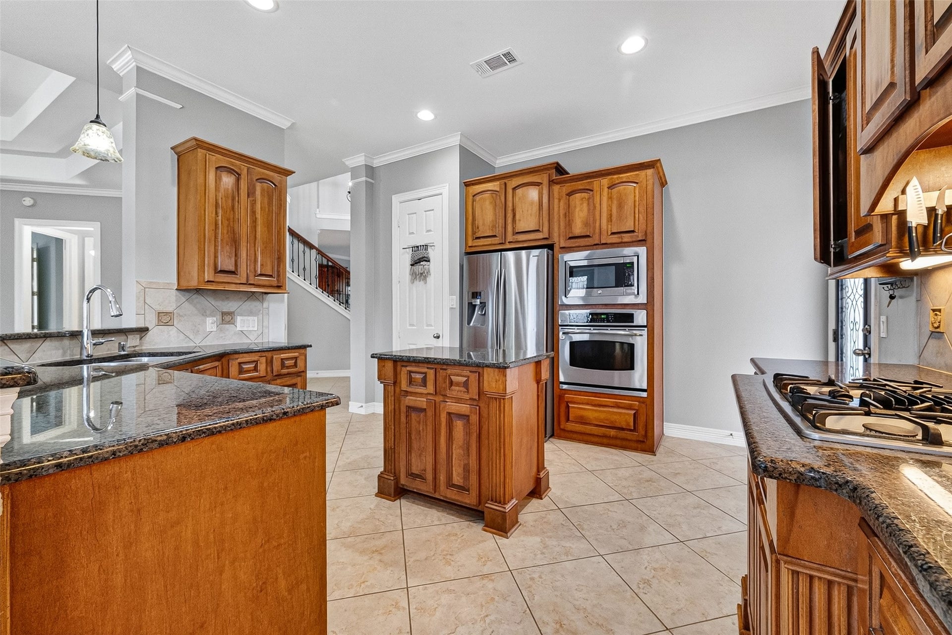 3102 Purple Finch, Missouri City, TX 77459 This inviting kitchen features modern appliances, warm wood cabinetry, and a spacious dining area with large windows providing plenty of natural light.