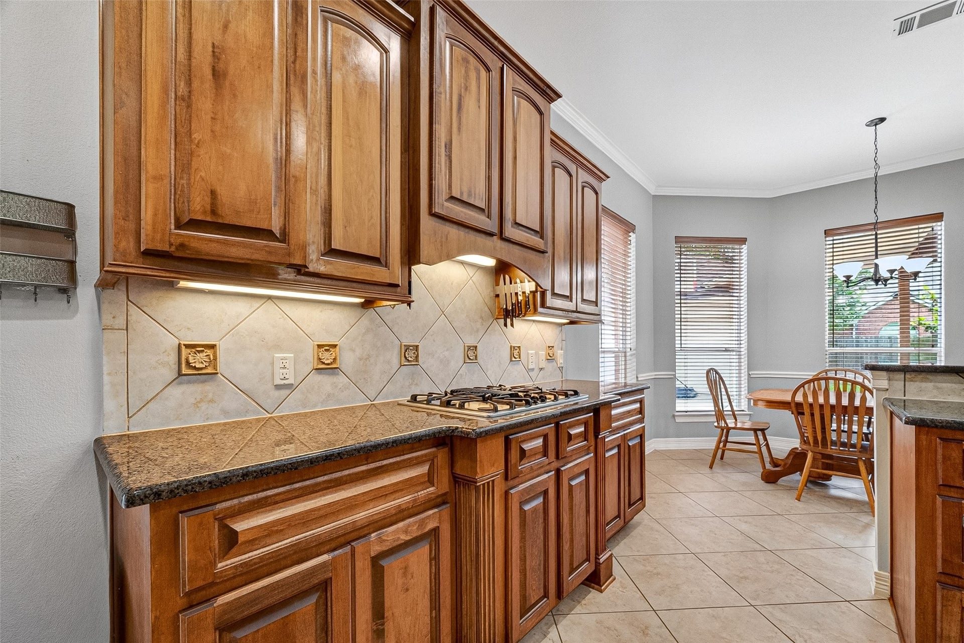 3102 Purple Finch, Missouri City, TX 77459 Spacious kitchen with elegant wooden cabinetry, granite countertops, and stainless steel appliances. Features a central island, gas cooktop, and ample natural light.