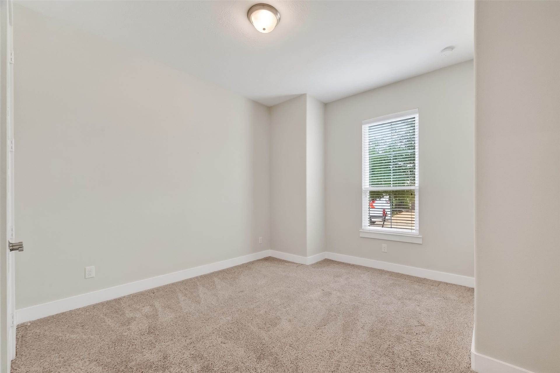 3415 Mckinney Ridge Drive, Houston, TX 77059 This is a bright bedroom has neutral-color walls and carpet flooring. It features a window with 2" wood blinds.