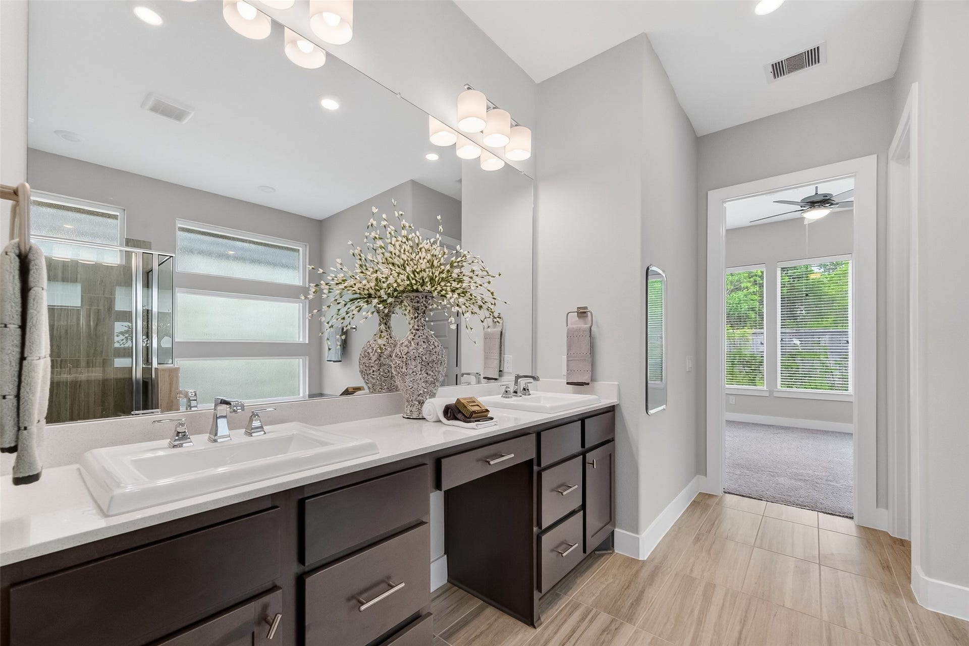 3415 Mckinney Ridge Drive, Houston, TX 77059 This modern bathroom features a double vanity with sleek dark cabinetry and white countertops.