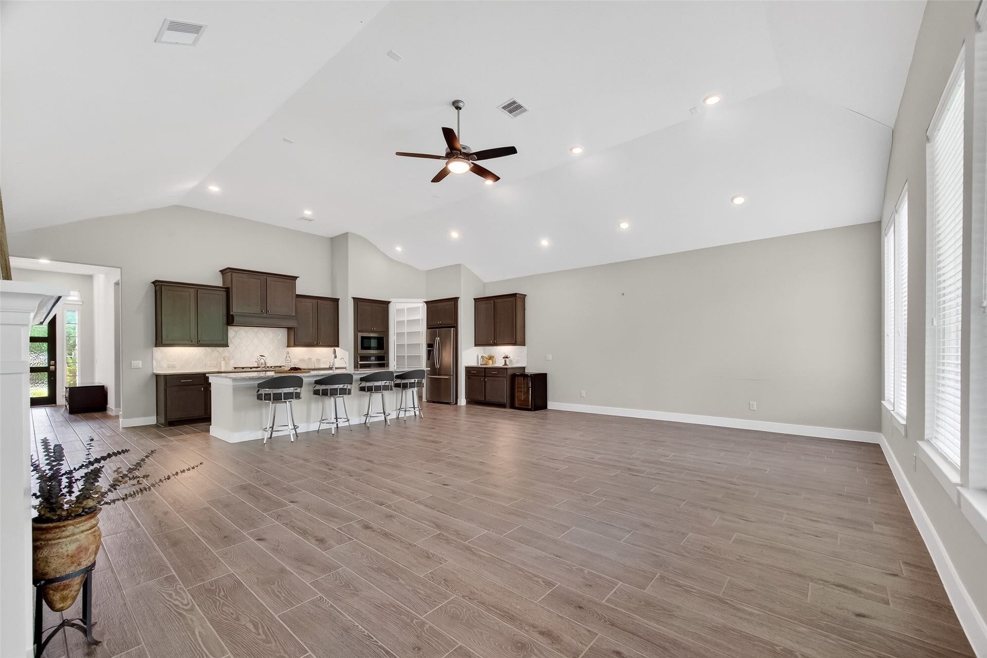 3415 Mckinney Ridge Drive, Houston, TX 77059 This spacious open-concept living area features recessed lighting, and ample natural light. The modern kitchen includes dark wood cabinetry, a central island with bar seating, offering a perfect blend of style and functionality.
