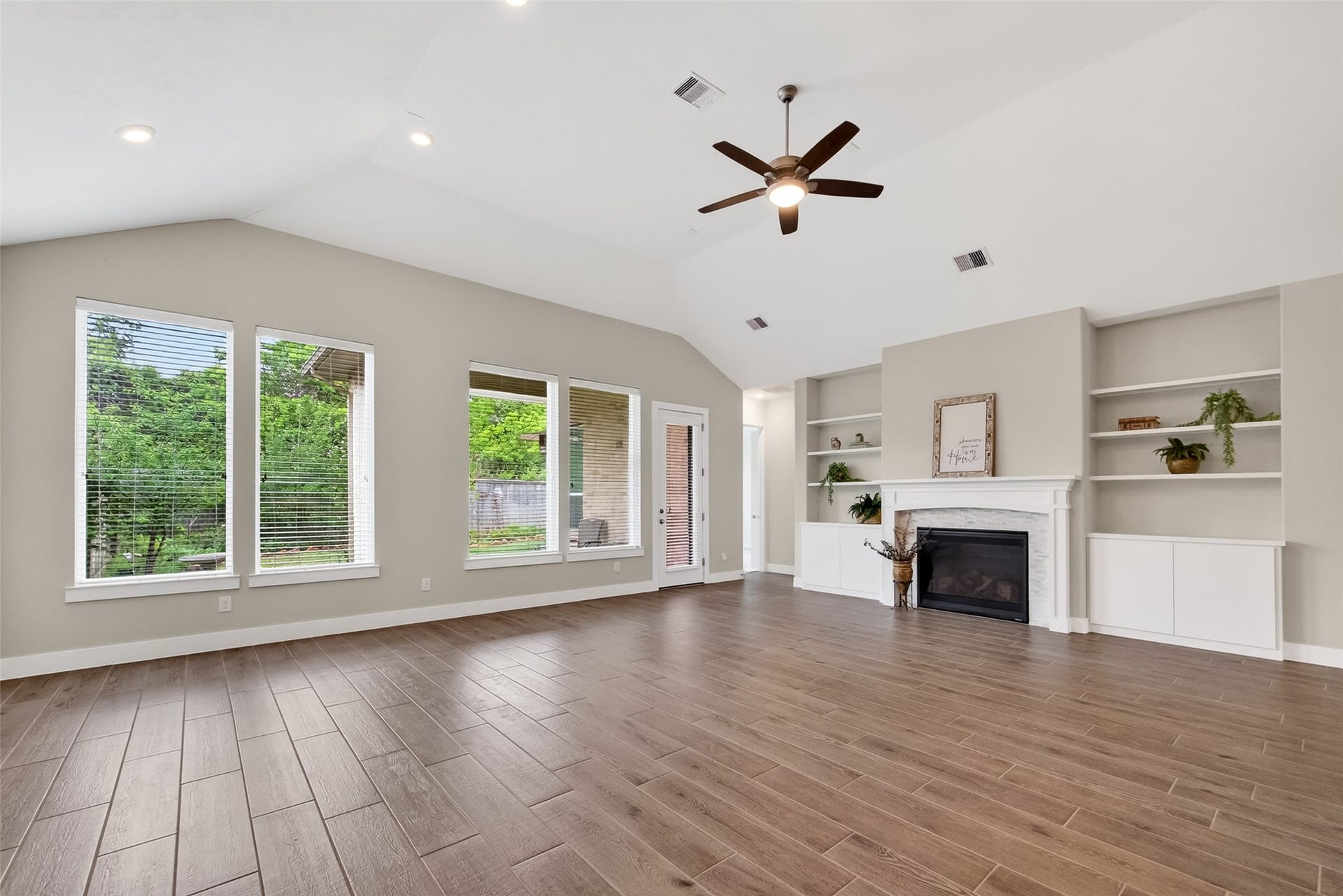 3415 Mckinney Ridge Drive, Houston, TX 77059 Large windows for natural light. Dual cabinets and built-in shelving surround the fireplace for storage and displays.
