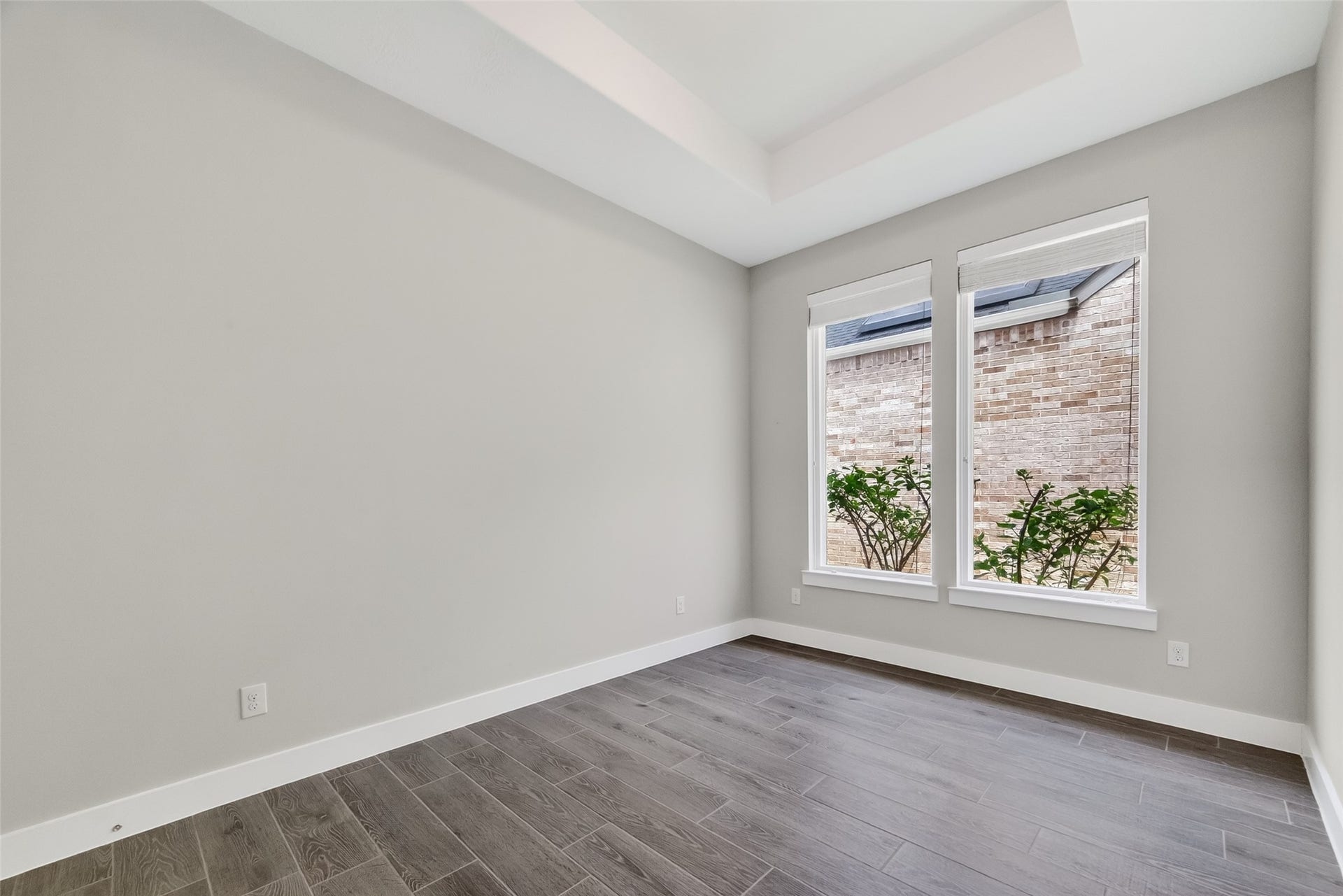 3415 Mckinney Ridge Drive, Houston, TX 77059 Two large windows provide natural light and a view of the flowering native bushes.