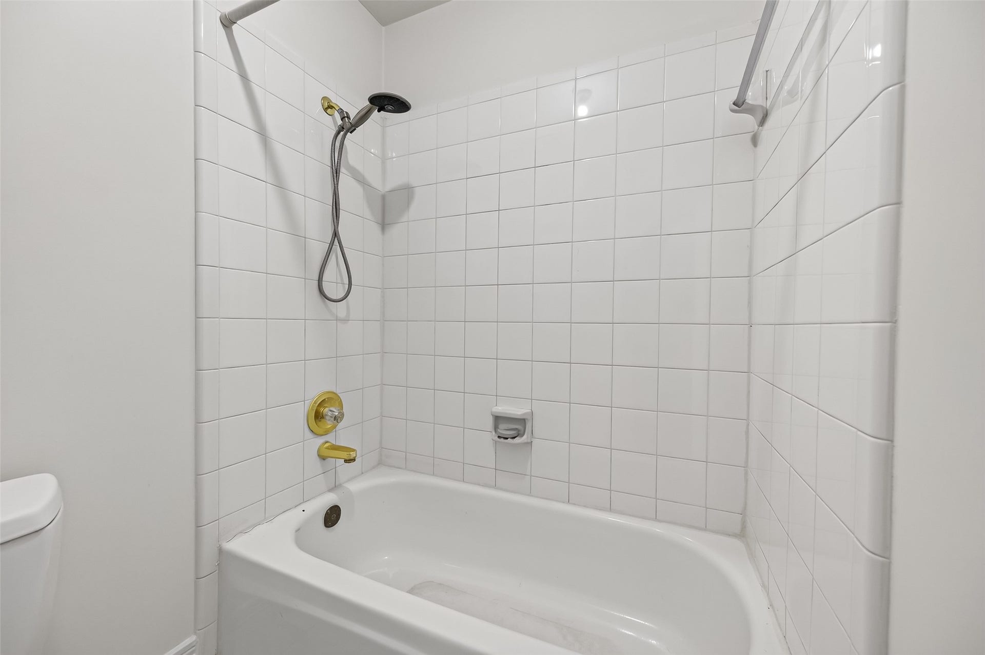 18 Tredington Street, Sugar Land, TX 77479 Bright and clean bathroom featuring a classic white tile shower and tub, perfect for relaxation.