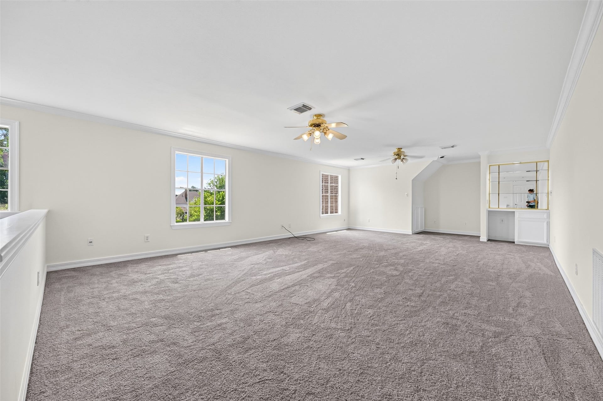 18 Tredington Street, Sugar Land, TX 77479 Spacious and bright carpeted room with large windows, ceiling fans, perfect for entertaining or relaxation.