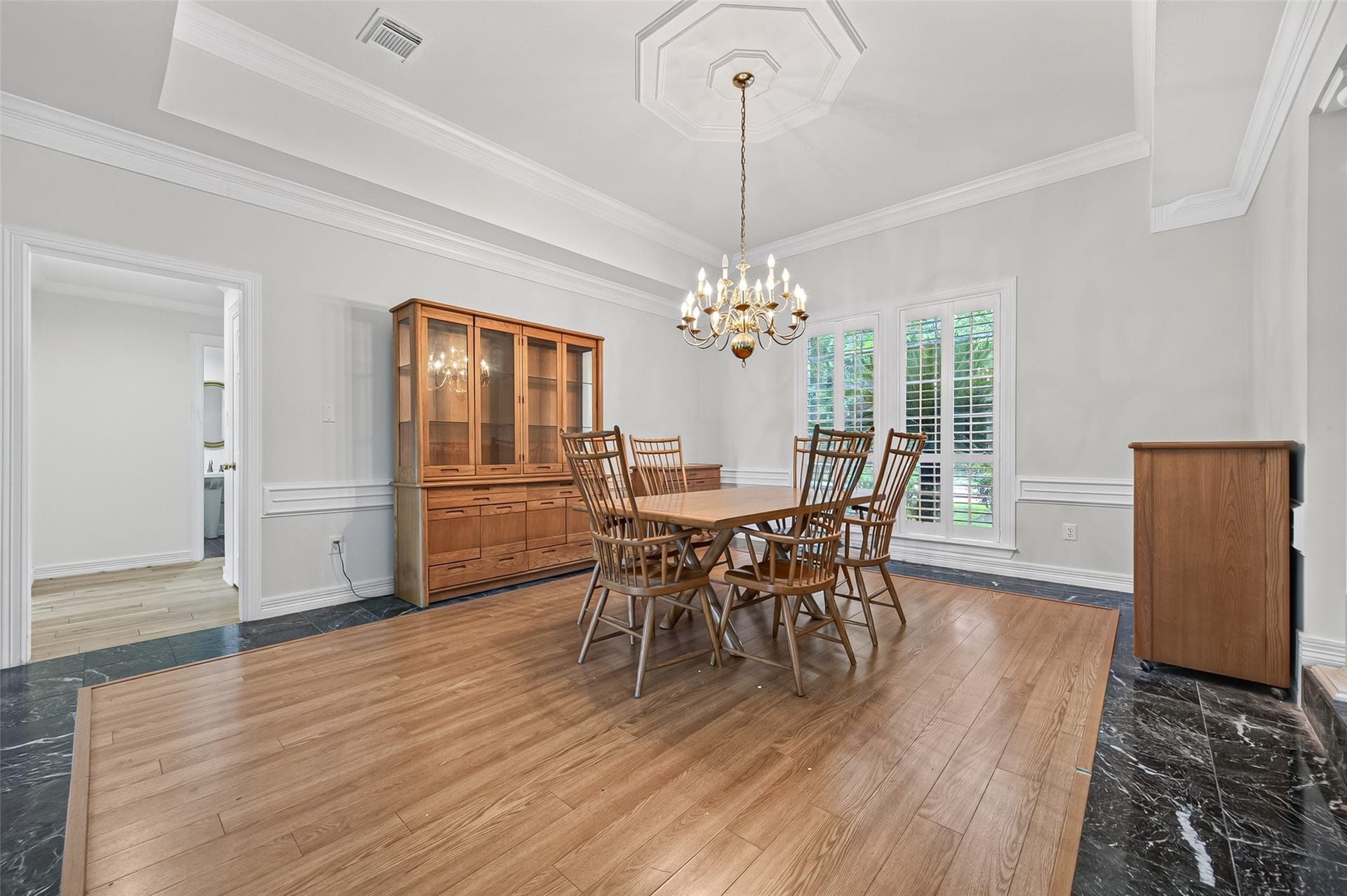 18 Tredington Street, Sugar Land, TX 77479 Elegant dining room featuring a classic chandelier, and abundant natural light through large windows with shutters.