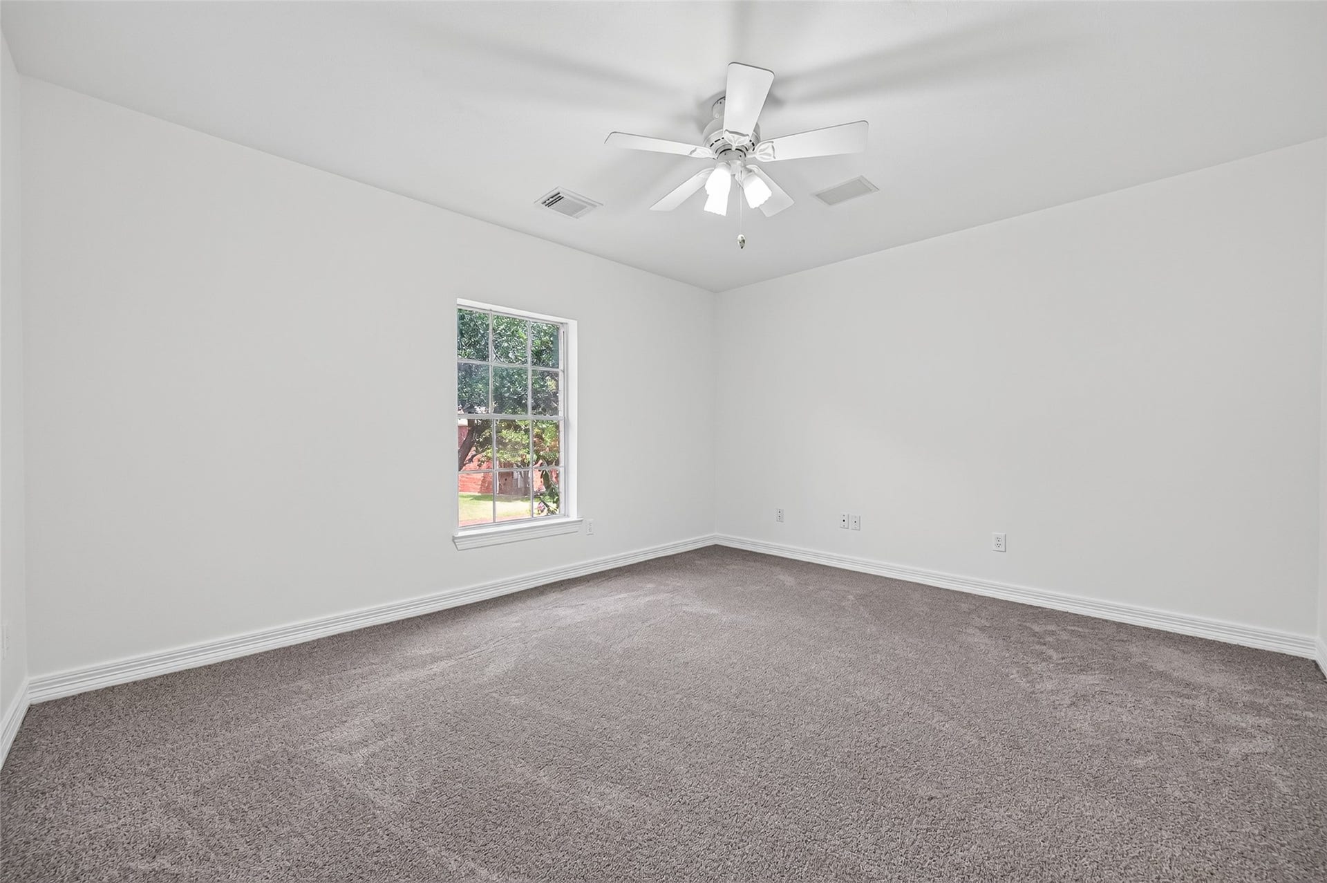 18 Tredington Street, Sugar Land, TX 77479 Bright and spacious bedroom featuring recent carpeting, a ceiling fan, and a large window inviting natural light.