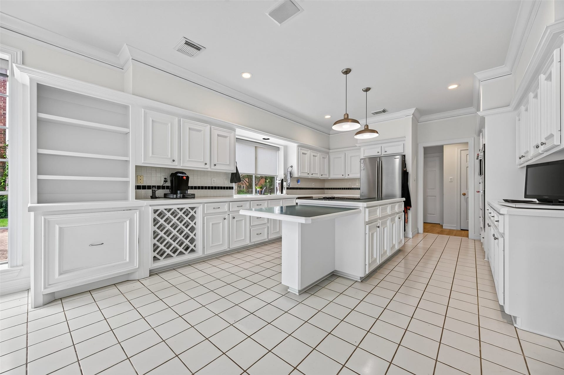 18 Tredington Street, Sugar Land, TX 77479 Bright and spacious kitchen featuring bright cabinetry, a large central island with pendant lighting, and ample counter space. Perfect for culinary enthusiasts.