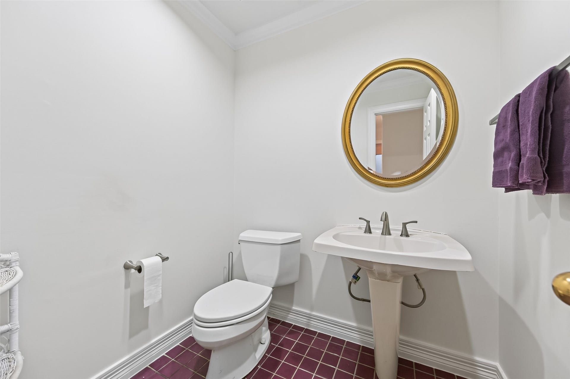 18 Tredington Street, Sugar Land, TX 77479 Charming powder room with elegant maroon tile flooring, a pedestal sink, and a classic oval mirror with a gold frame.