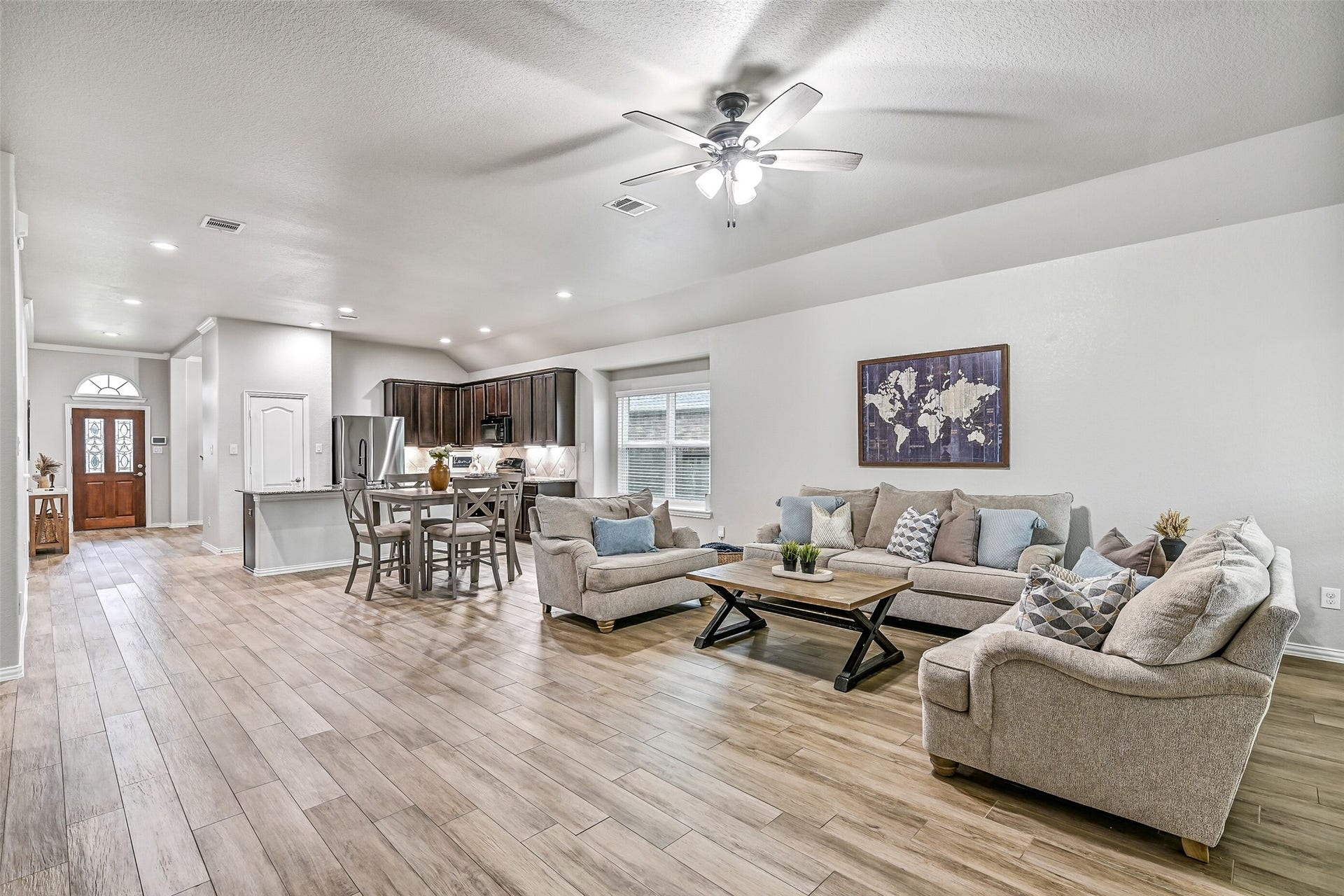 Another view of the family room showcases its generous proportions and versatile layout. Large rear windows invite natural light inside while offering views of the oversized backyard and covered patio beyond.