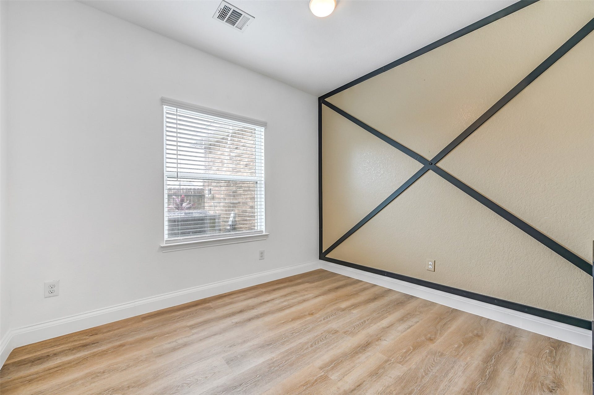 A stylish accent wall gives this secondary bedroom a custom touch while maintaining the home's clean, neutral color palette. Spacious proportions allow plenty of flexibility for furniture placement and everyday living.